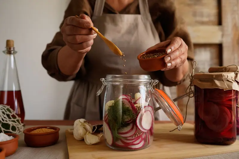 Hands preparing pickled vegetables in a jar, capturing a rustic and organic lifestyle