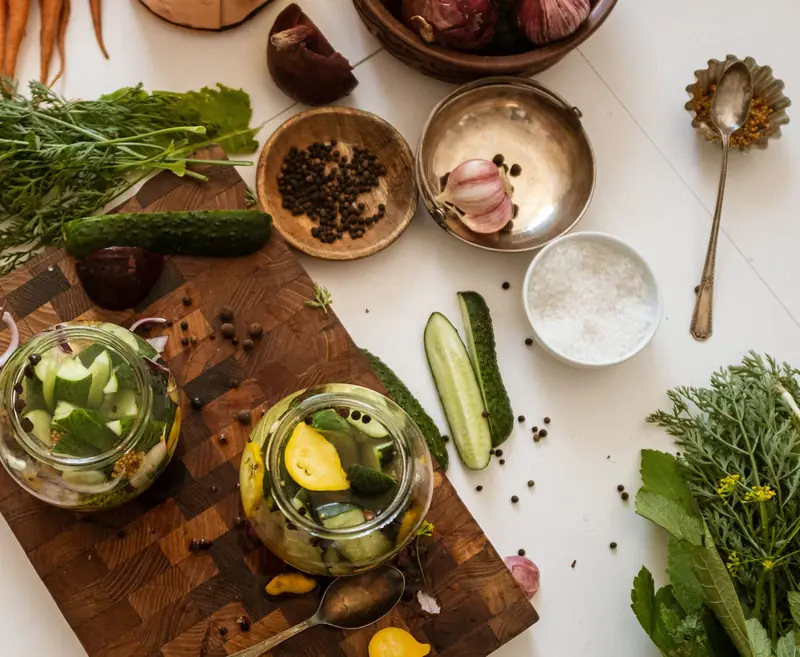 Aerial view of kitchen table with fresh vegetables and pickles preparation