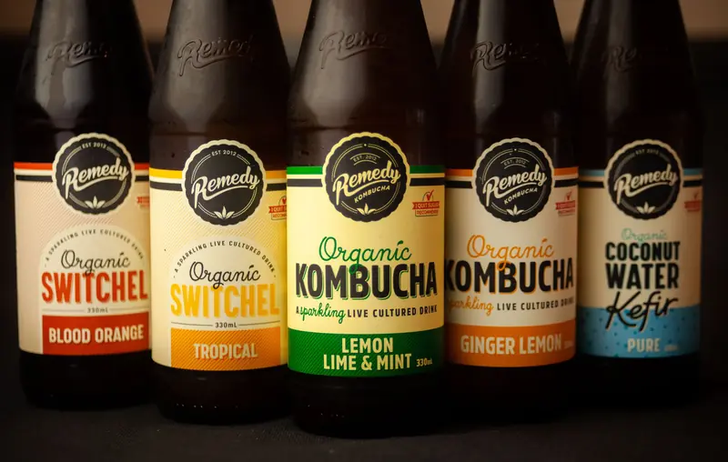 Close-up of five bottles featuring organic kombucha, switchel, and kefir with various flavors