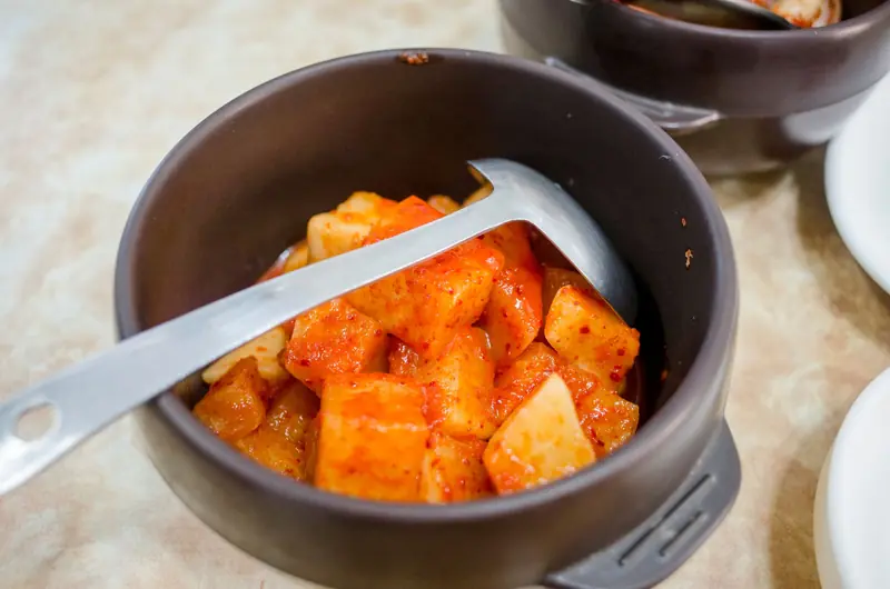 Close-up of homemade spicy kimchi in a ceramic bowl, showcasing vibrant flavors